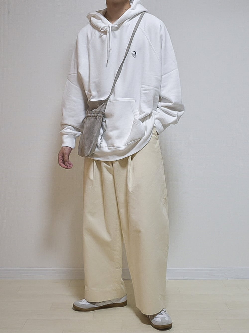 ホワイト系のパーカー、ホワイト系のチノパンツ、ホワイト系のスニーカーを着用したメンズの夏コーディネートの2枚目の写真