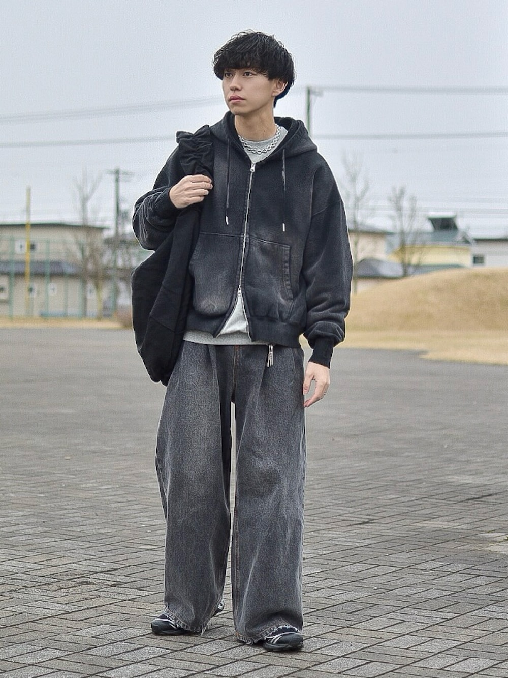 ブラック系のパーカー、グレー系のスウェット、ブラック系のデニムパンツを着用したメンズの春コーディネートの5枚目の写真