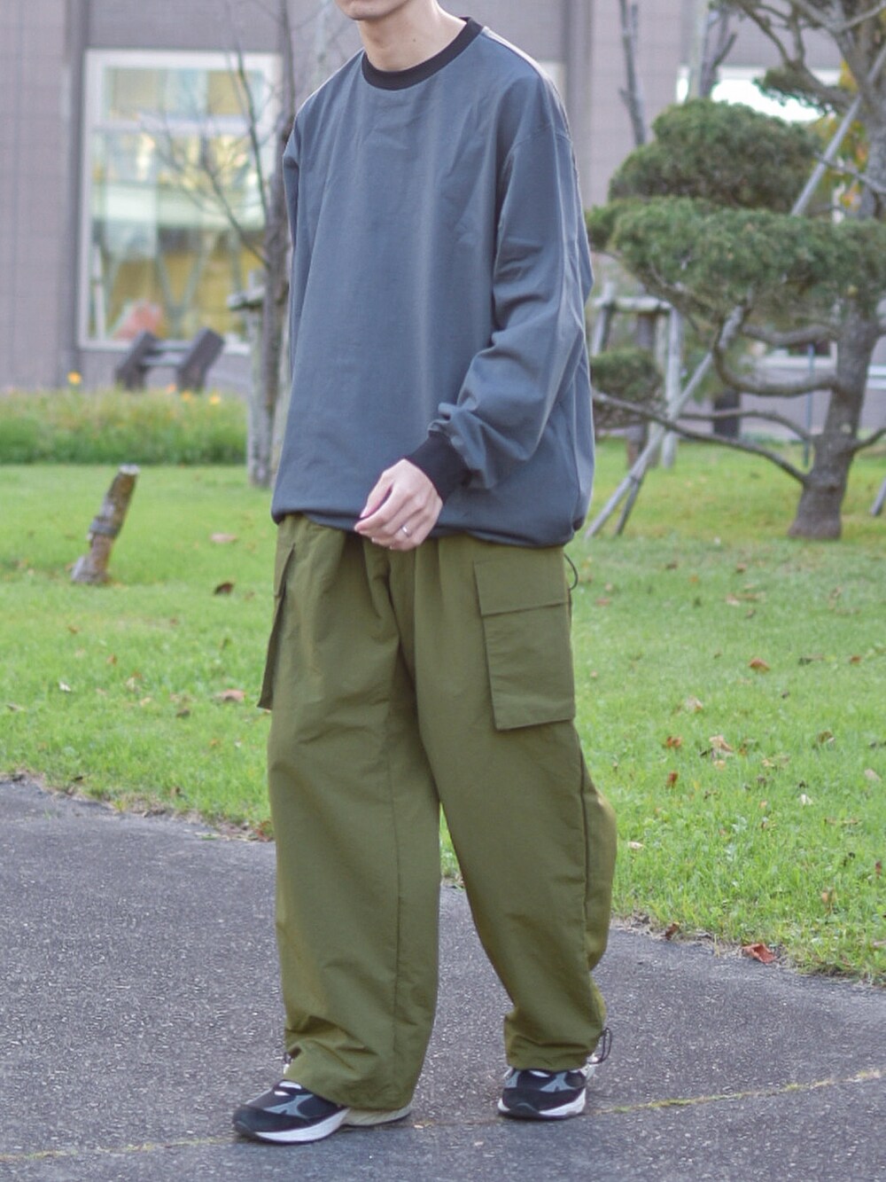 ブラック系のシューズ、グレー系のTシャツ/カットソー、グリーン系のカーゴパンツを着用したメンズの秋コーディネートの4枚目の写真