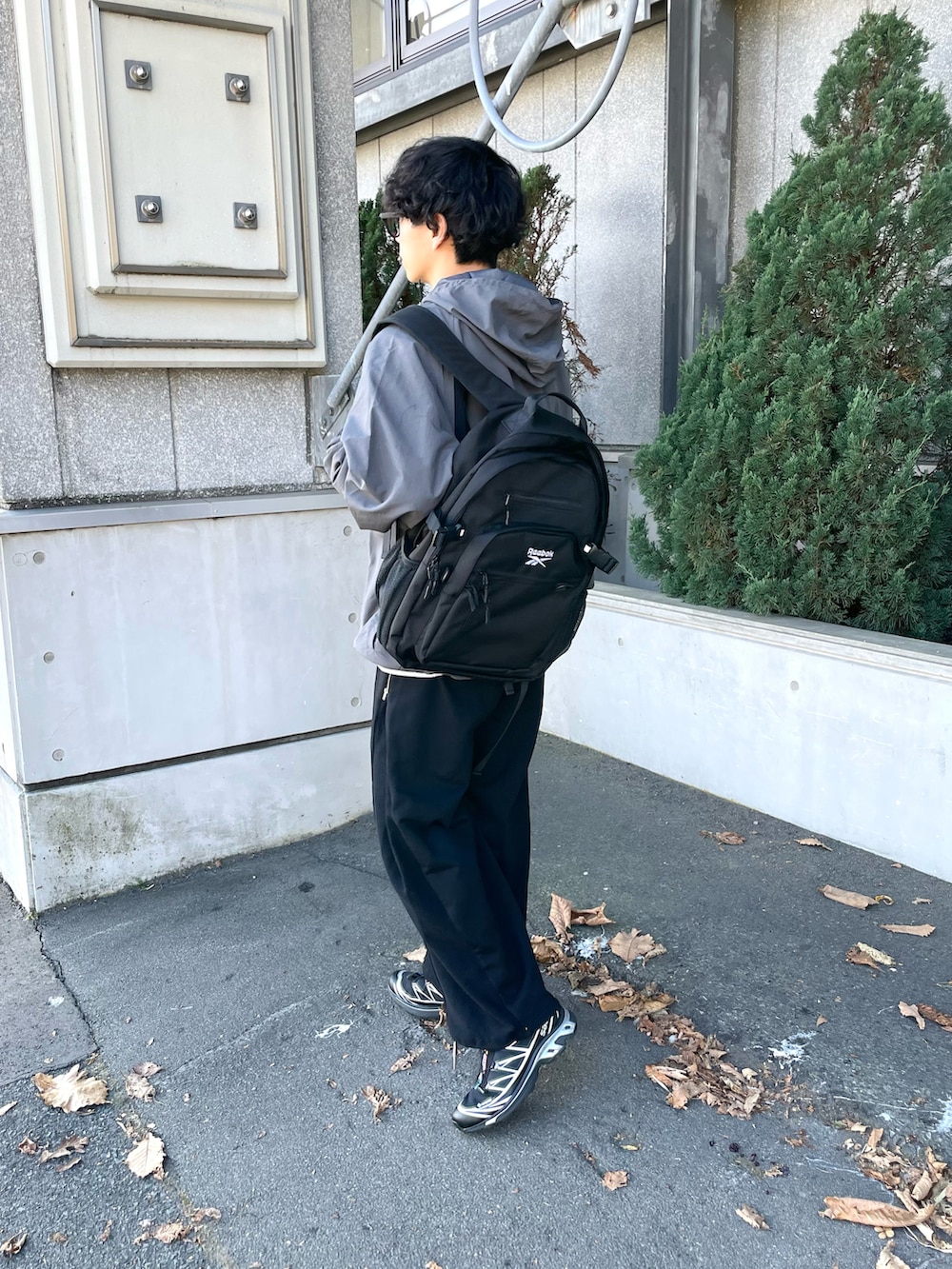 グレー系のナイロンジャケット、グレー系のスウェット、ブラック系のスウェットパンツを着用したメンズの秋コーディネートの5枚目の写真