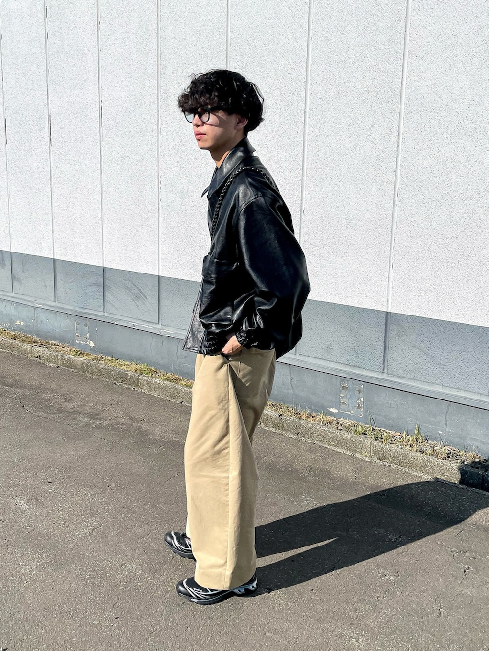 ブラック系のブルゾン、ブラック系のショルダーバッグ、ベージュ系のスウェットを着用したメンズの秋コーディネートの4枚目の写真