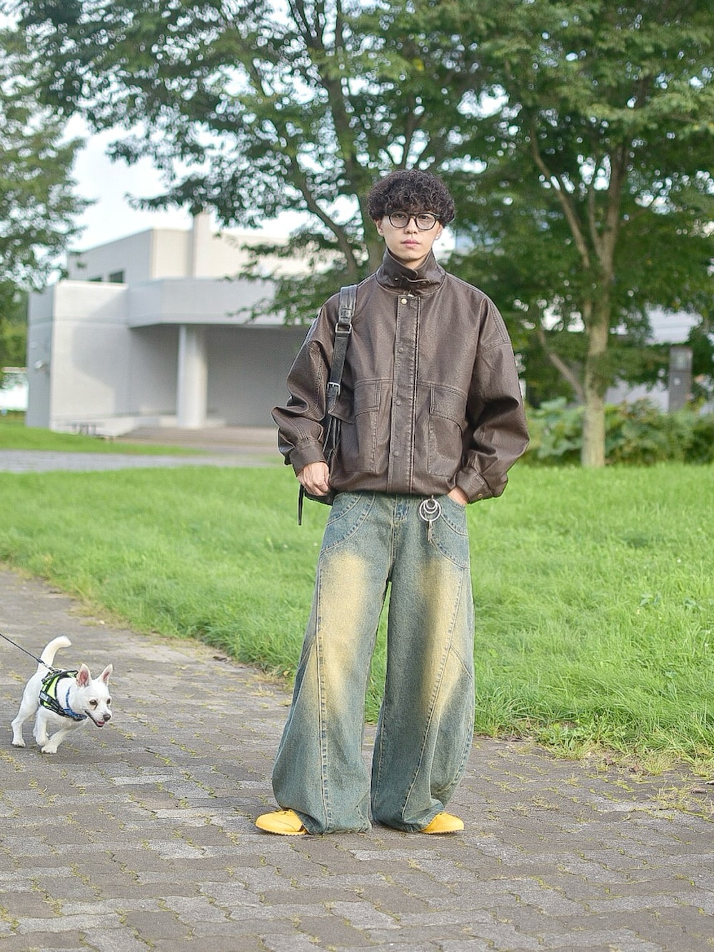 ブラウン系のブルゾン、ブルー系のデニムパンツ、イエロー系のスニーカーを着用したメンズの秋コーディネートの4枚目の写真