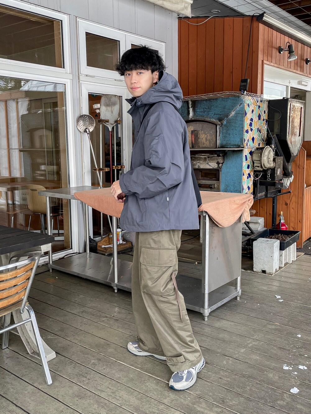 グレー系のマウンテンパーカー、グリーン系のカーゴパンツ、グレー系のスニーカーを着用したメンズの冬コーディネートの3枚目の写真