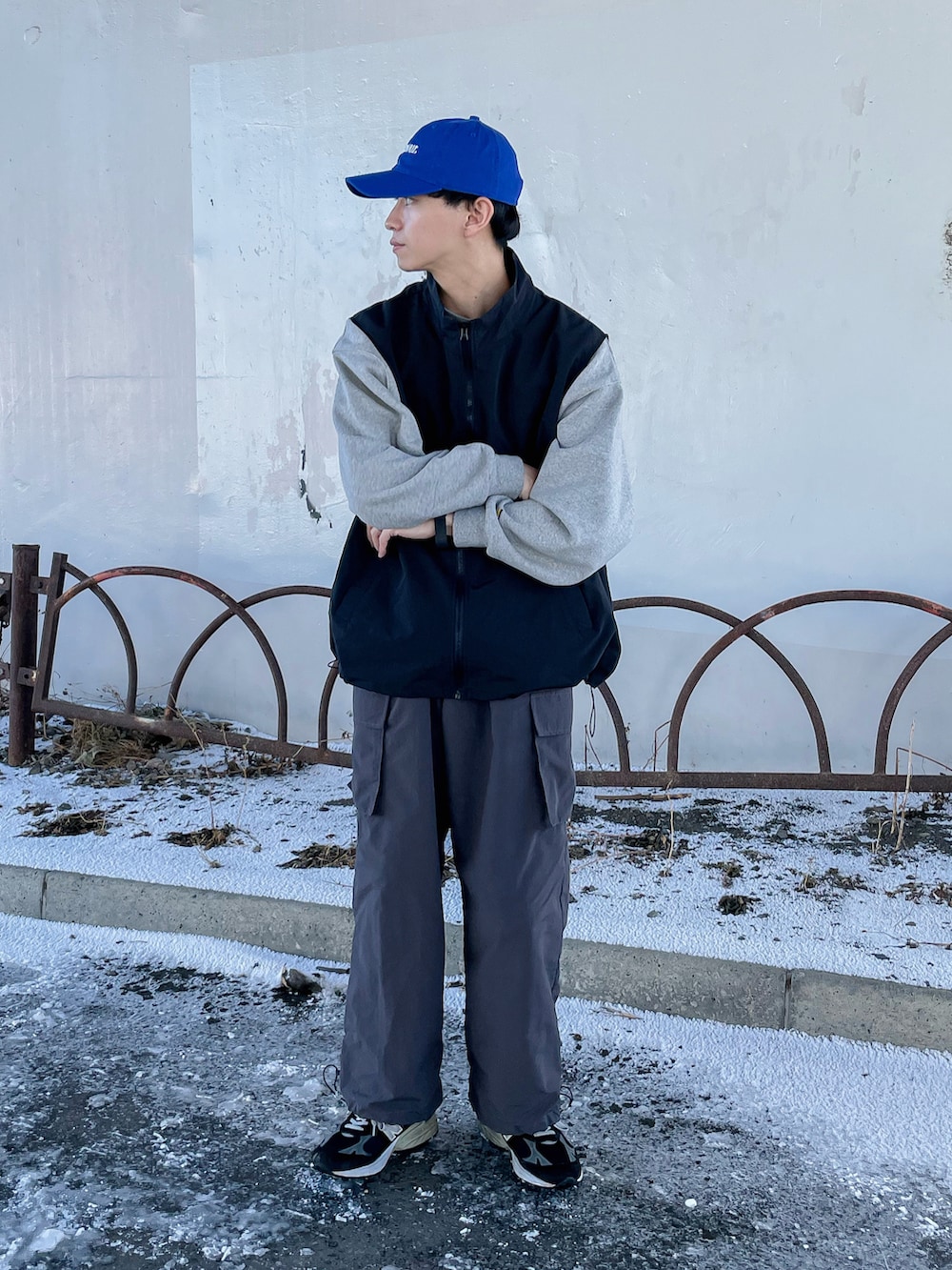 グレー系のカーゴパンツ、ブラック系のベスト、ブラック系のシューズを着用したメンズの冬コーディネートの4枚目の写真