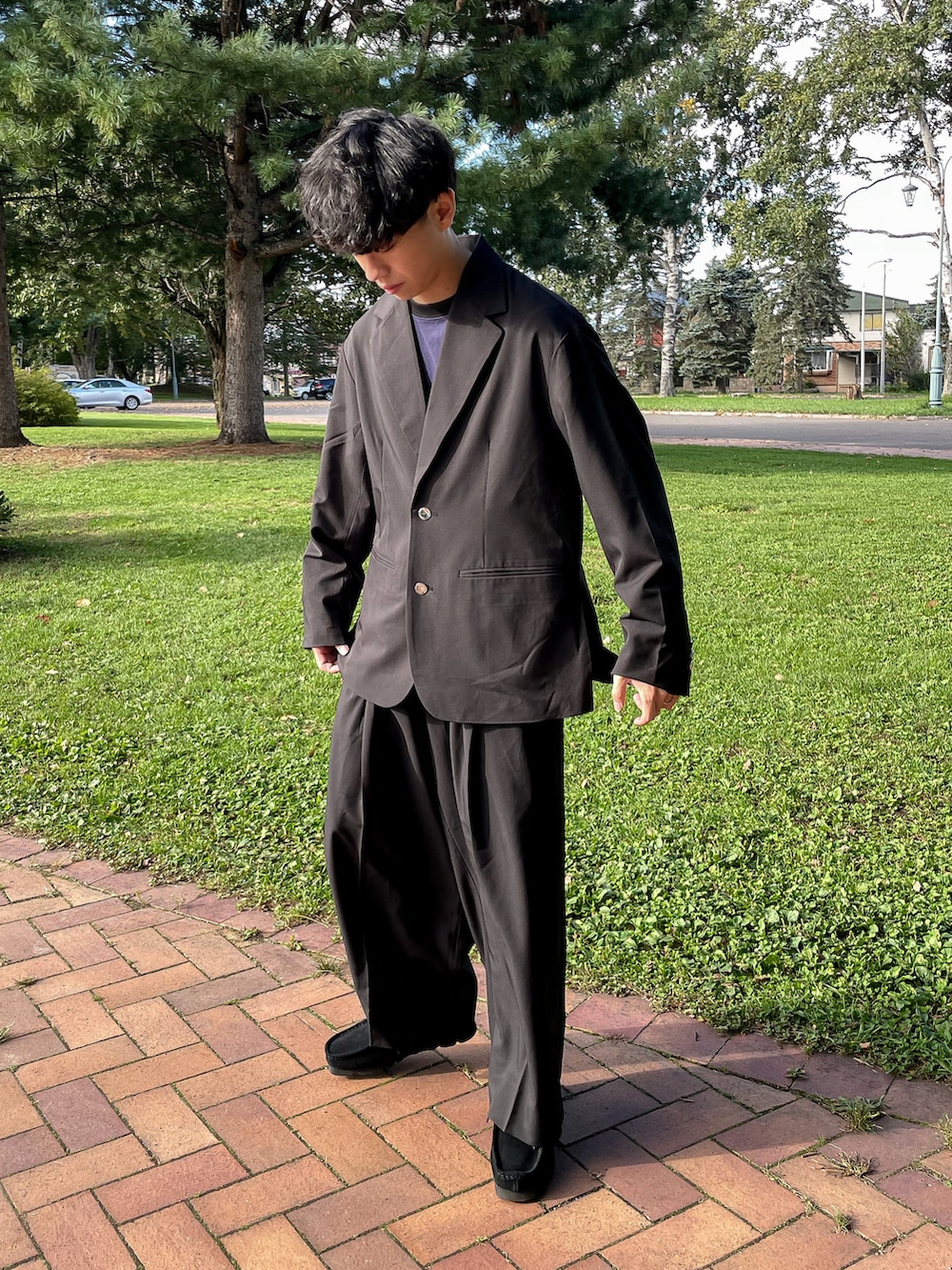 ブラック系のテーラードジャケット、ブラック系のその他パンツ、ブラック系のモカシン/デッキシューズを着用したメンズの秋コーディネートの2枚目の写真