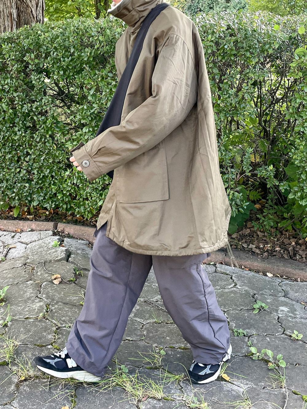 グリーン系のモッズコート、グレー系のカーゴパンツを着用したメンズの秋コーディネートの3枚目の写真