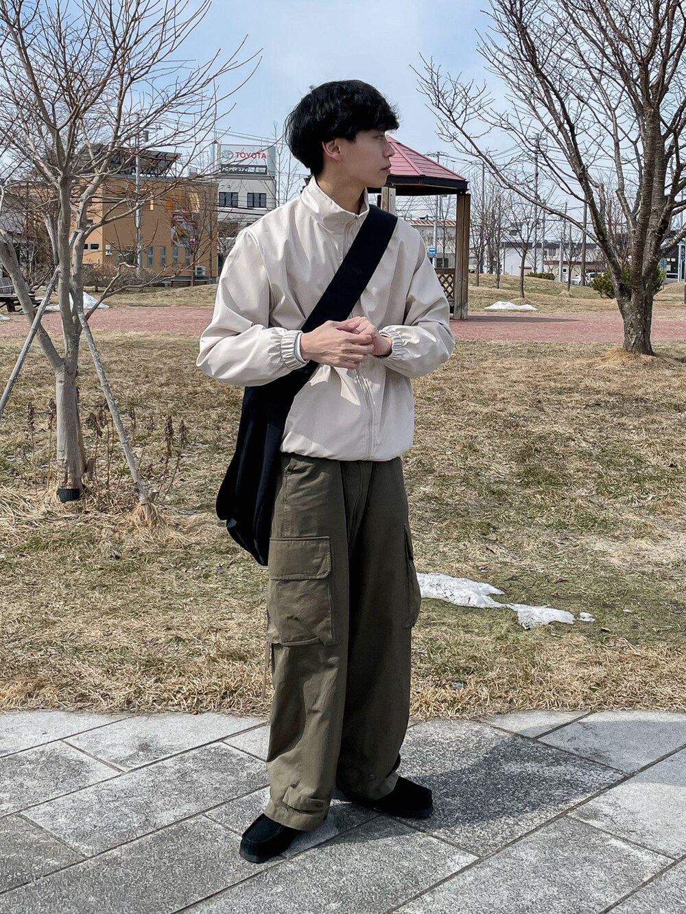 ベージュ系のジャケット/アウター、グリーン系のカーゴパンツ、ブラック系のモカシン/デッキシューズを着用したメンズの春コーディネートの2枚目の写真