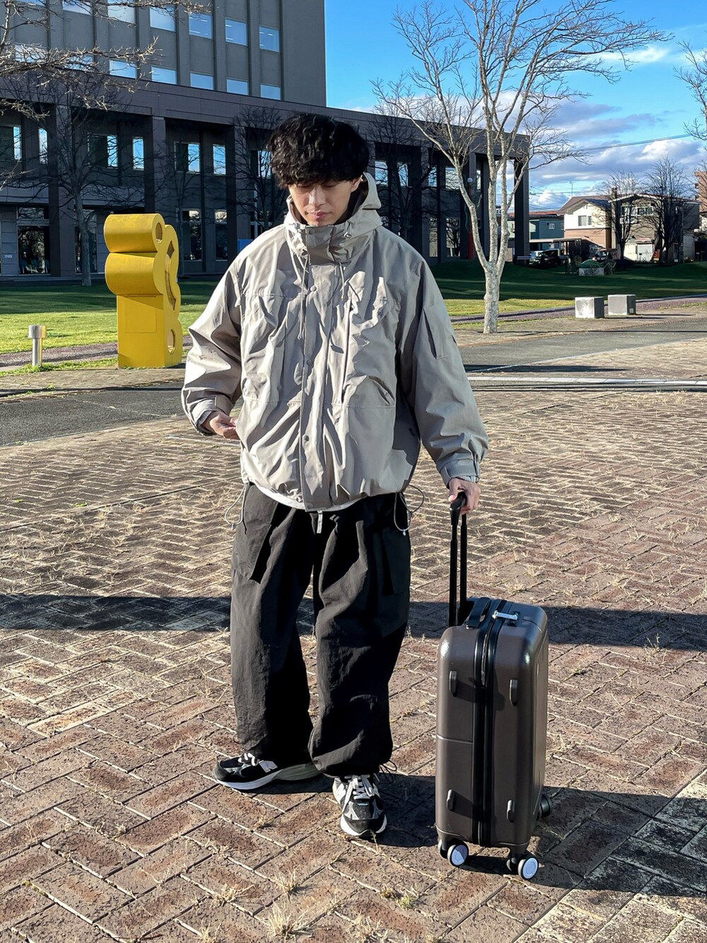 ベージュ系のマウンテンパーカー、ブラック系のカーゴパンツ、ブラック系のシューズを着用したメンズの秋コーディネートの4枚目の写真