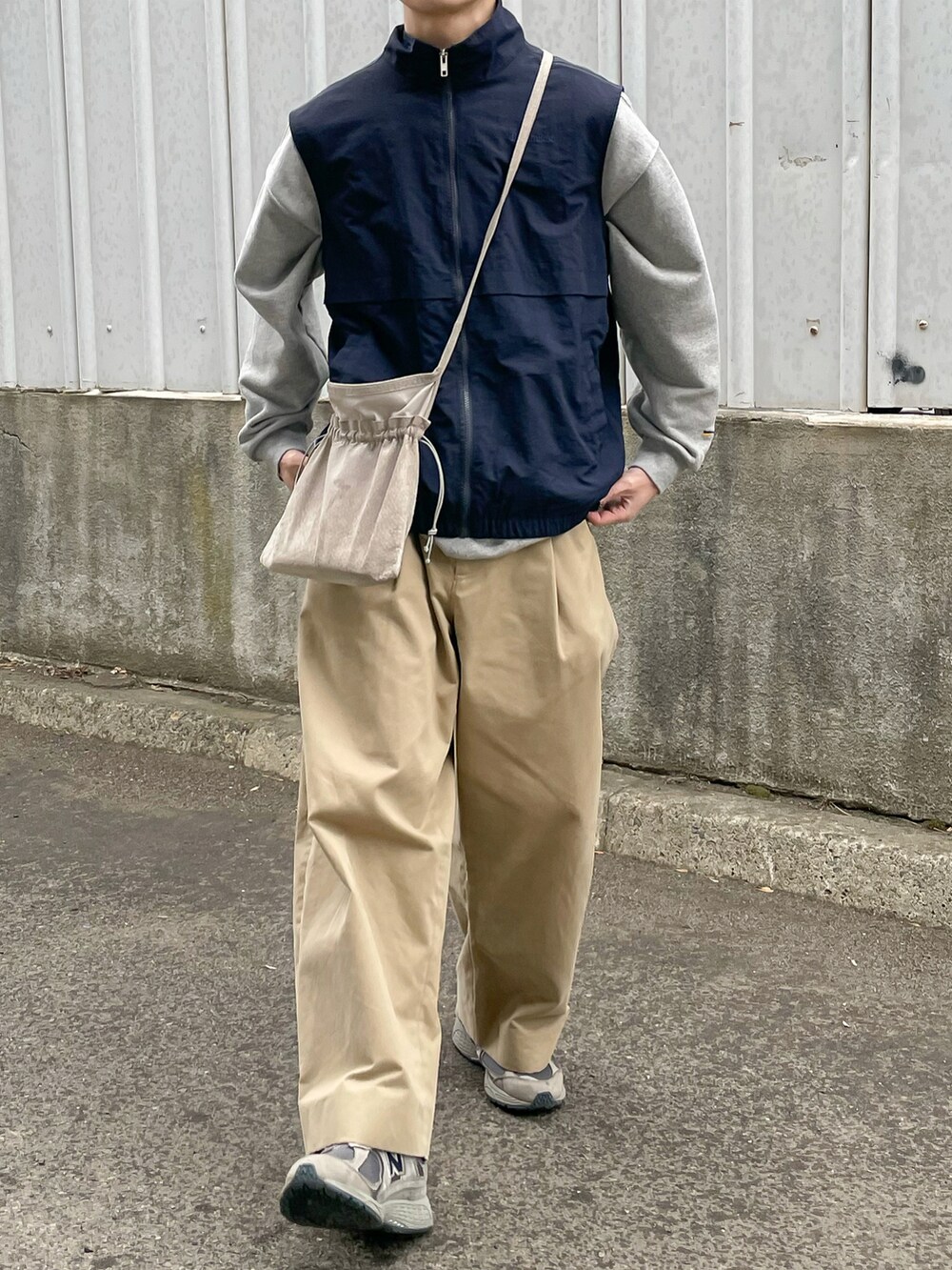 ブルー系のベスト、ベージュ系のその他パンツ、グレー系のスニーカーを着用したメンズの春コーディネートの4枚目の写真