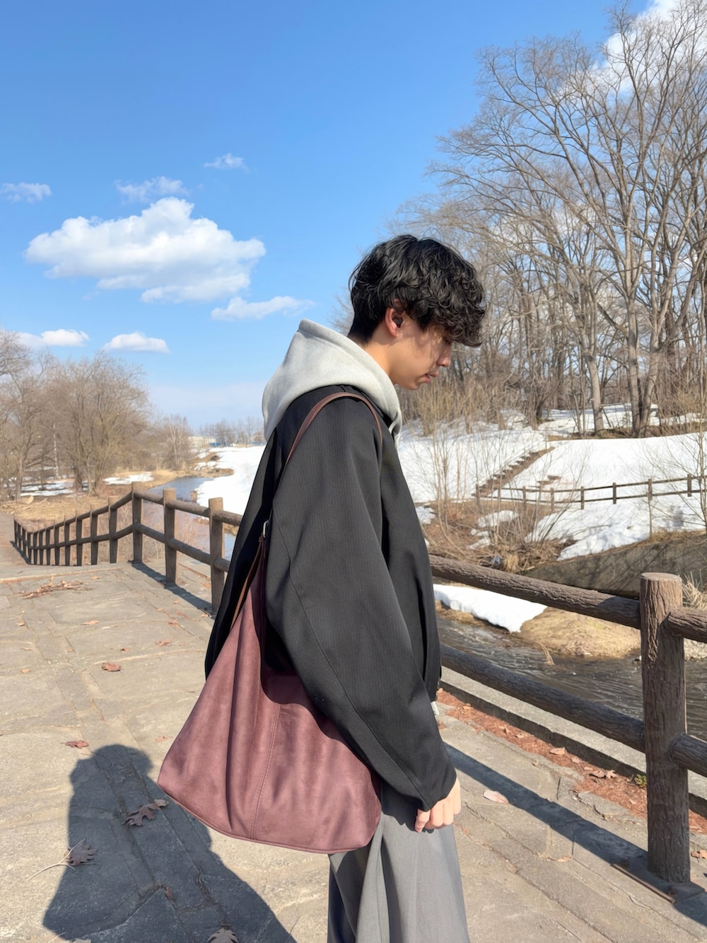 その他のブルゾン、ブラウン系のショルダーバッグ、グレー系のスラックスを着用したメンズの春コーディネートの5枚目の写真