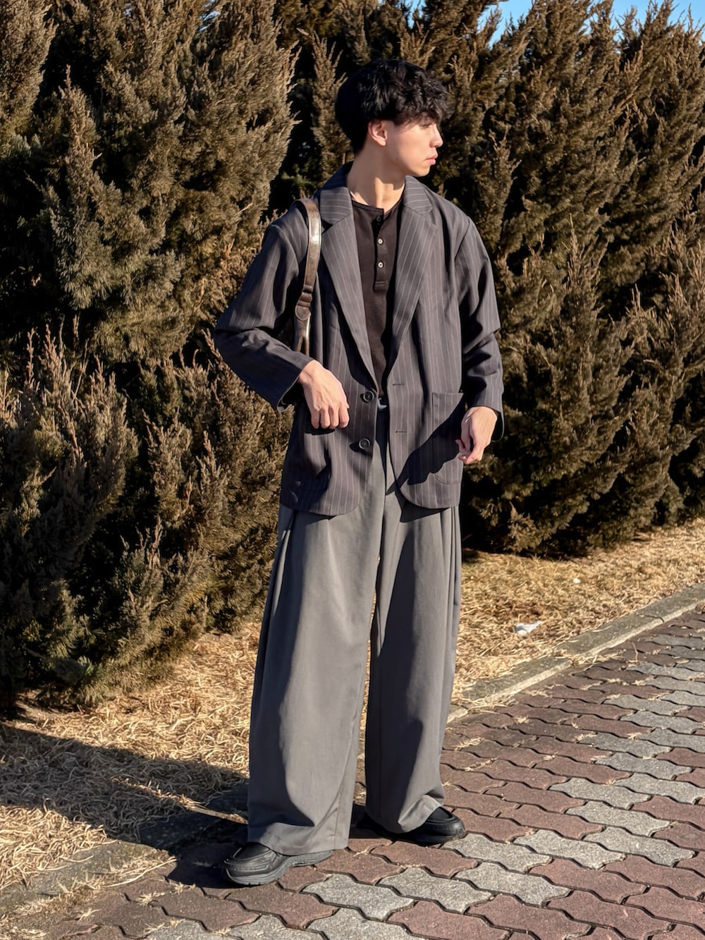 ブラック系のTシャツ/カットソー、グレー系のスラックス、ブラック系のシューズを着用したメンズの冬コーディネートの2枚目の写真