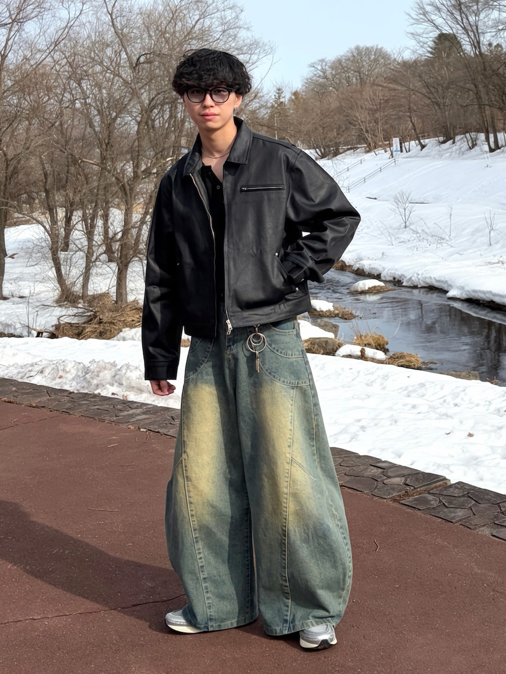 ブルー系のデニムパンツ、ブラック系のTシャツ/カットソー、ブラック系のデニムジャケットを着用したメンズの冬コーディネートの2枚目の写真