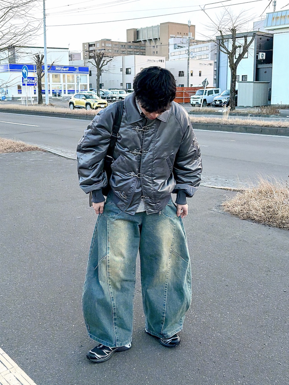 グレー系のブルゾン、ホワイト系のシャツ/ブラウス、ブルー系のデニムパンツを着用したメンズの冬コーディネートの3枚目の写真