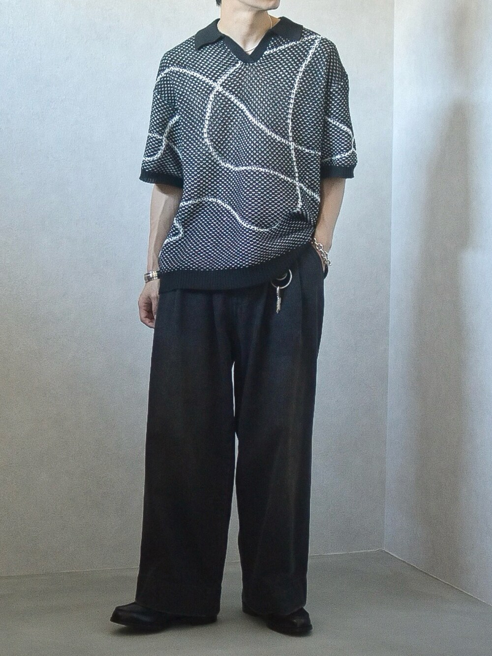ブラック系のニット/セーター、ブラック系のデニムパンツ、ブラック系のローファーを着用したメンズの夏コーディネートの2枚目の写真