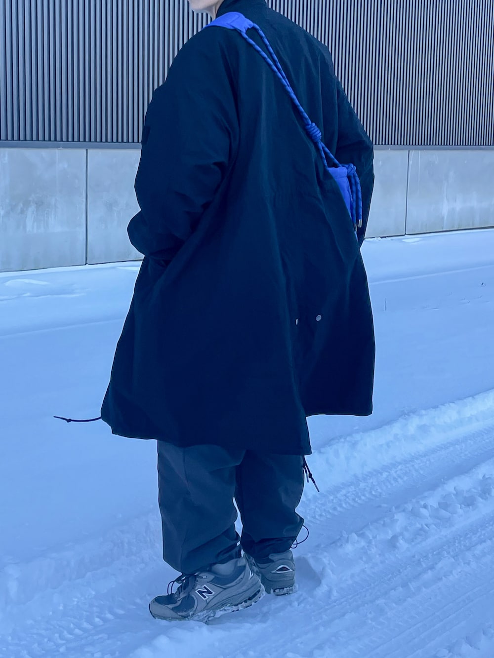 グレー系のカーゴパンツ、ブラック系のスウェット、ブラック系のモッズコートを着用したメンズの冬コーディネートの3枚目の写真