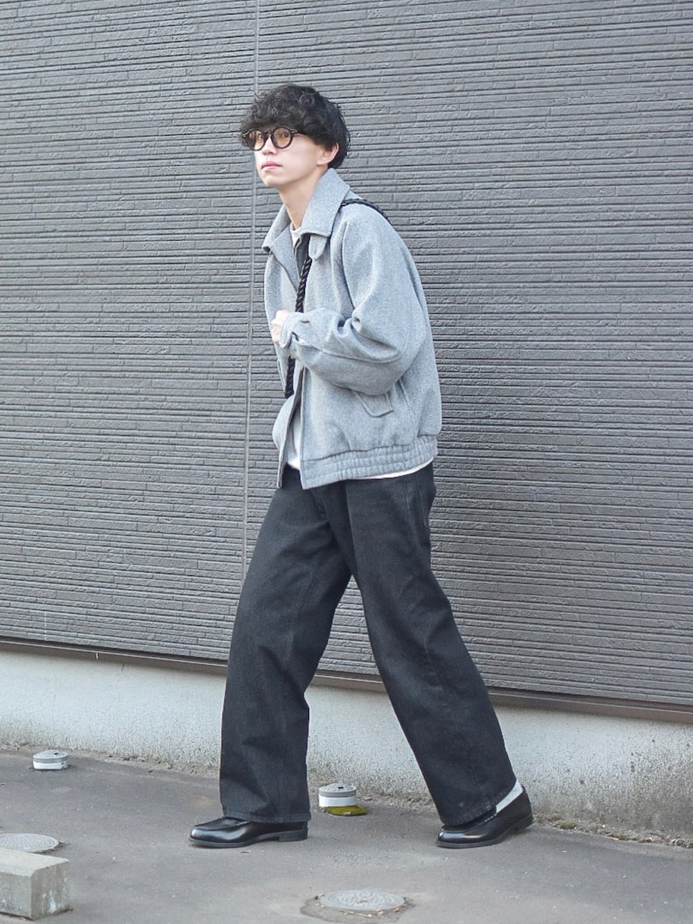 グレー系のブルゾン、グレー系のスウェット、ブラック系のデニムパンツを着用したメンズの冬コーディネートの3枚目の写真