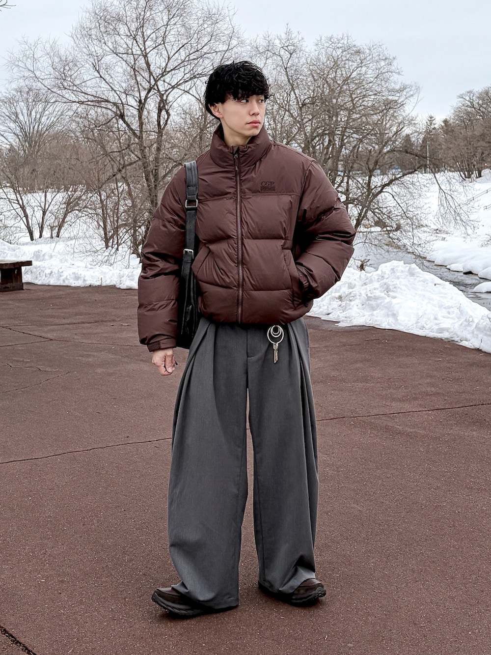 グレー系のスウェット、ブラウン系のダウンジャケット/コート、グレー系のスラックスを着用したメンズの冬コーディネートの3枚目の写真