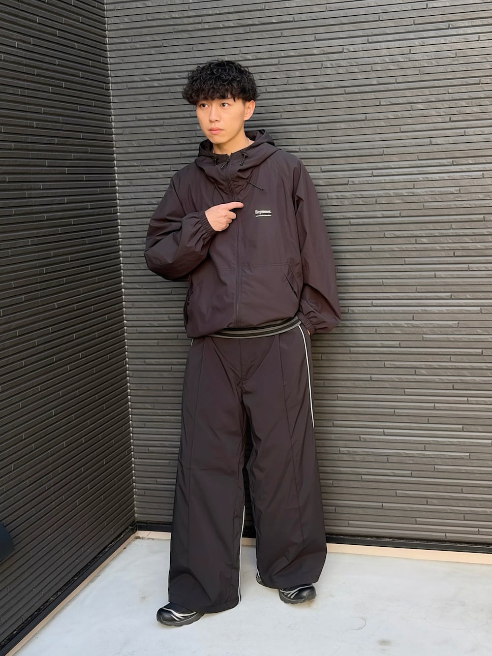 ブラック系のスウェットパンツ、ブラック系のTシャツ/カットソー、ブラック系のナイロンジャケットを着用したメンズの春コーディネートの2枚目の写真