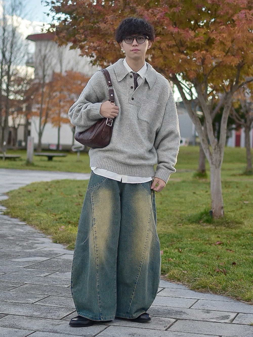 グレー系のポロシャツ、ホワイト系のシャツ/ブラウス、ブルー系のデニムパンツを着用したメンズの秋コーディネートの3枚目の写真