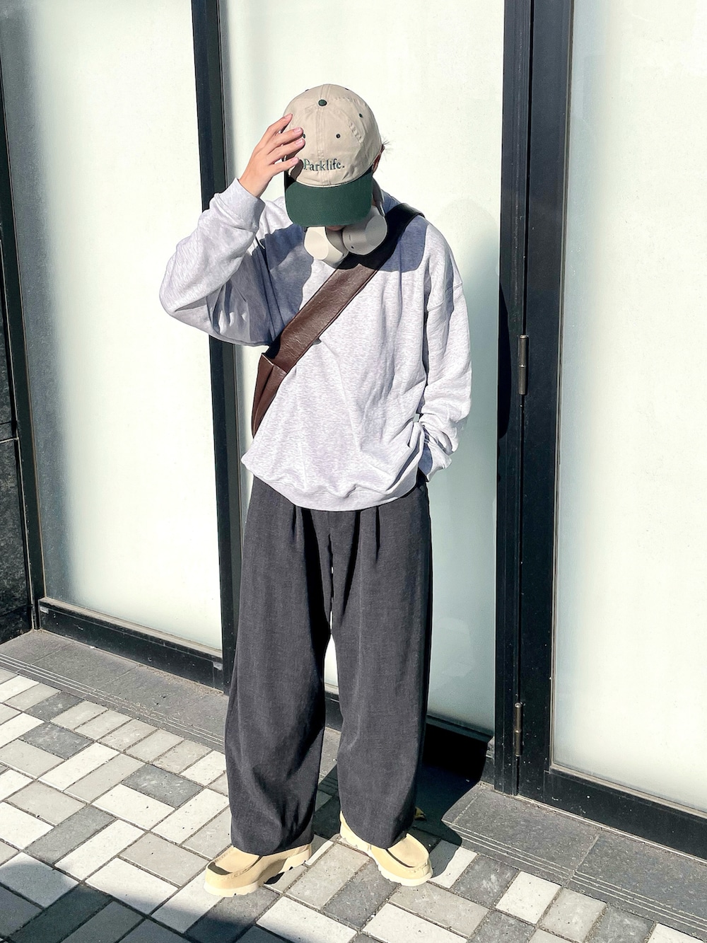 グレー系のスウェット、グレー系のスラックス、ベージュ系のモカシン/デッキシューズを着用したメンズの秋コーディネートの2枚目の写真