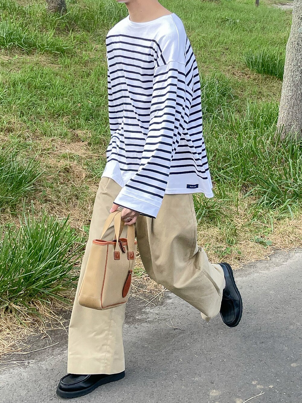 ホワイト系のトップス、ベージュ系のその他パンツ、ブラック系のローファーを着用したメンズの秋コーディネートの2枚目の写真