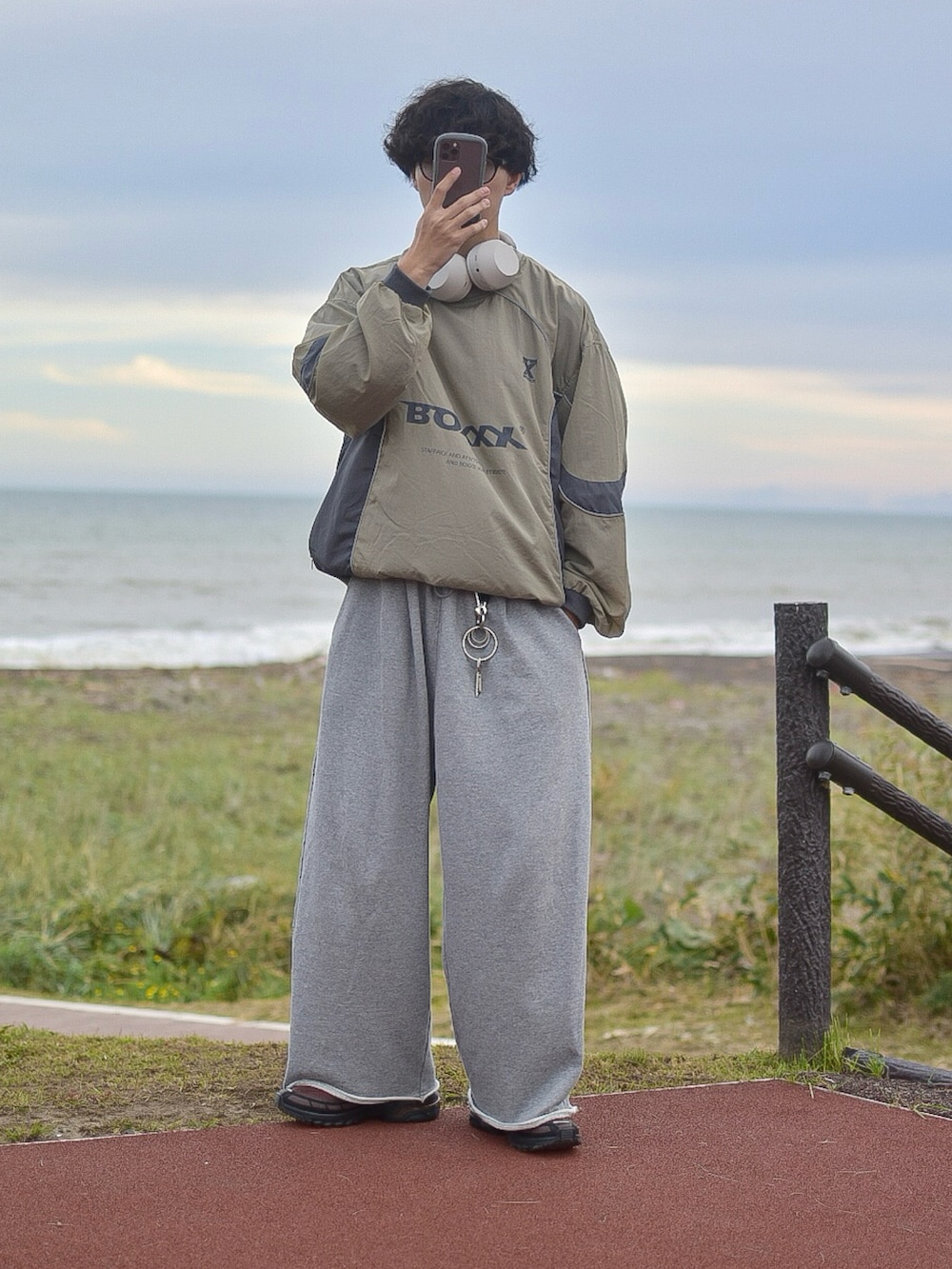 グリーン系のスウェット、グレー系のスウェットパンツ、ブラウン系のスニーカーを着用したメンズの秋コーディネートの5枚目の写真