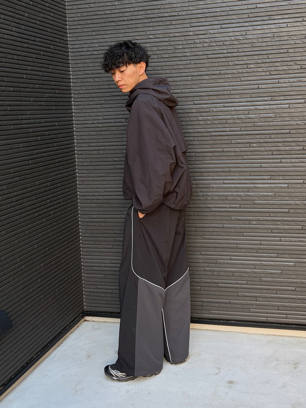 ブラック系のスウェットパンツ、ブラック系のTシャツ/カットソー、ブラック系のナイロンジャケットを着用したメンズの春コーディネートの4枚目の写真