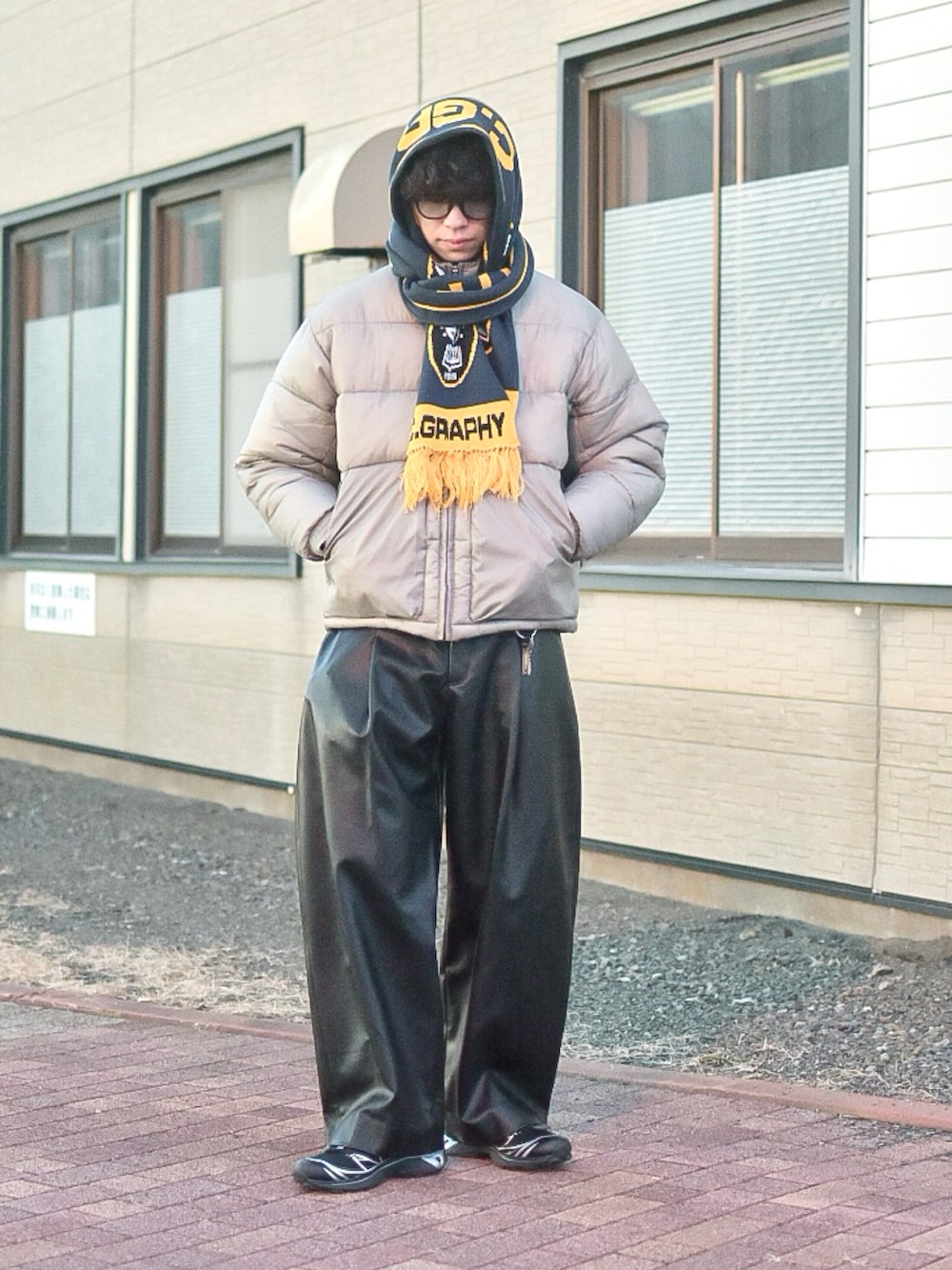 グレー系のダウンジャケット/コート、ブラック系のその他パンツ、ブラック系のスニーカーを着用したメンズの冬コーディネートの3枚目の写真