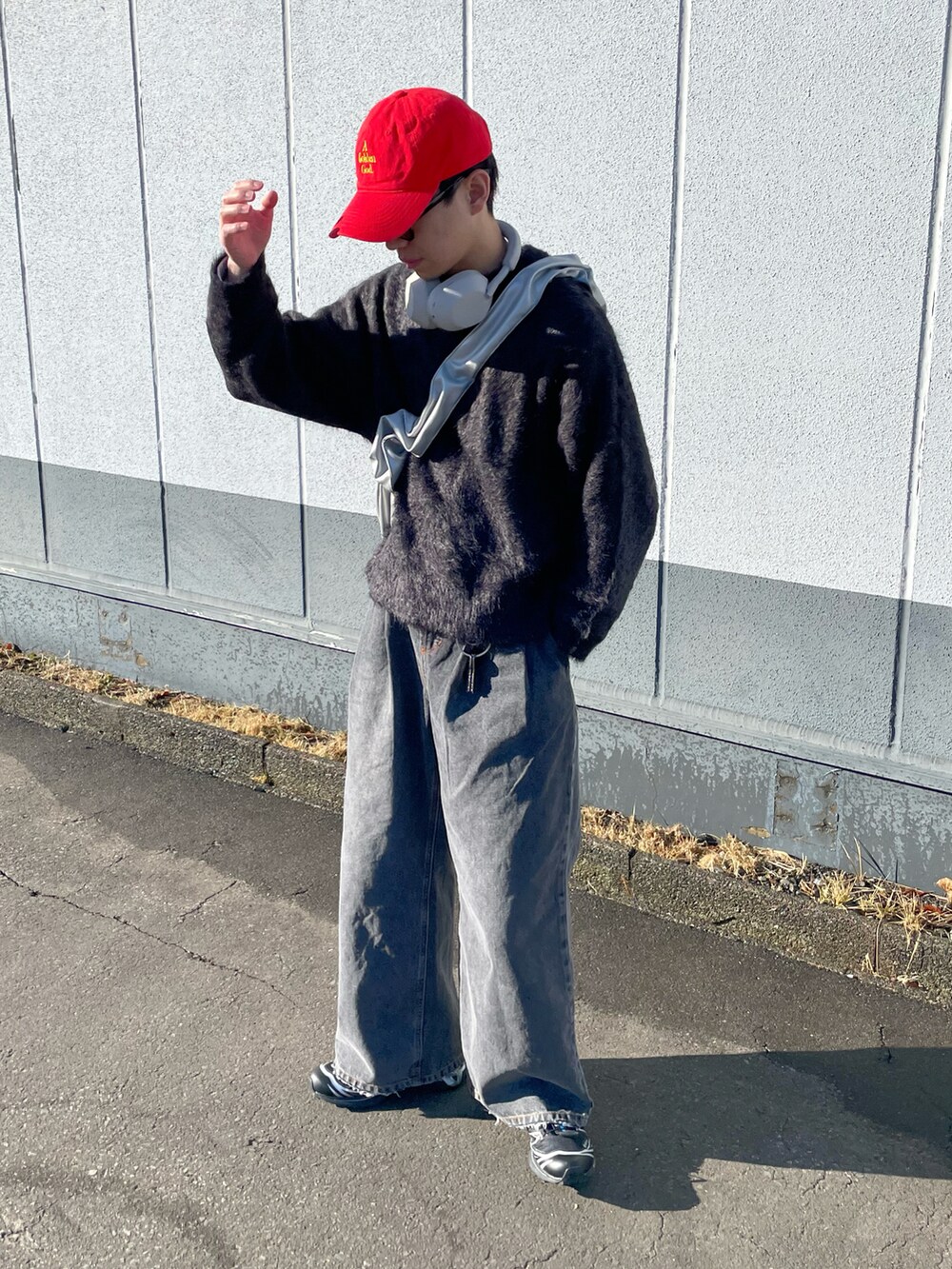 グレー系のニット/セーター、ブラック系のデニムパンツ、シルバー系のショルダーバッグを着用したメンズの冬コーディネートの2枚目の写真