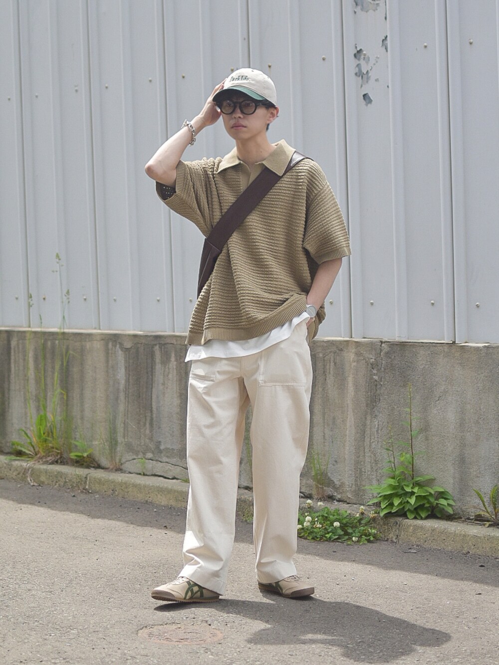グリーン系のポロシャツ、ホワイト系のデニムパンツ、ベージュ系のスニーカーを着用したメンズの夏コーディネートの2枚目の写真