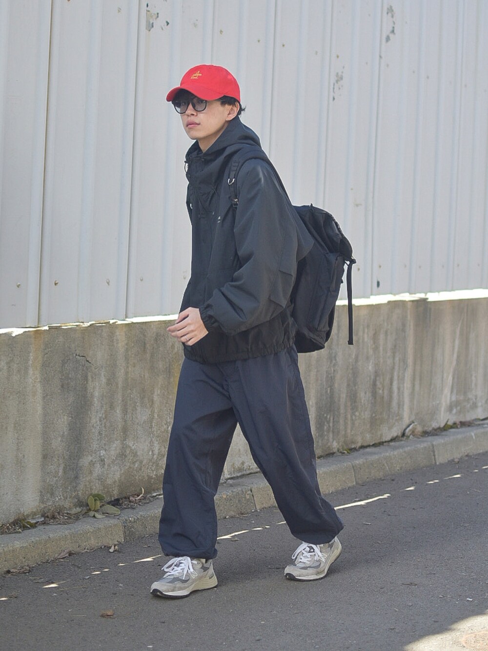 ブラック系のその他パンツ、ブラック系のバックパック/リュック、グレー系のスニーカーを着用したメンズの春コーディネートの4枚目の写真