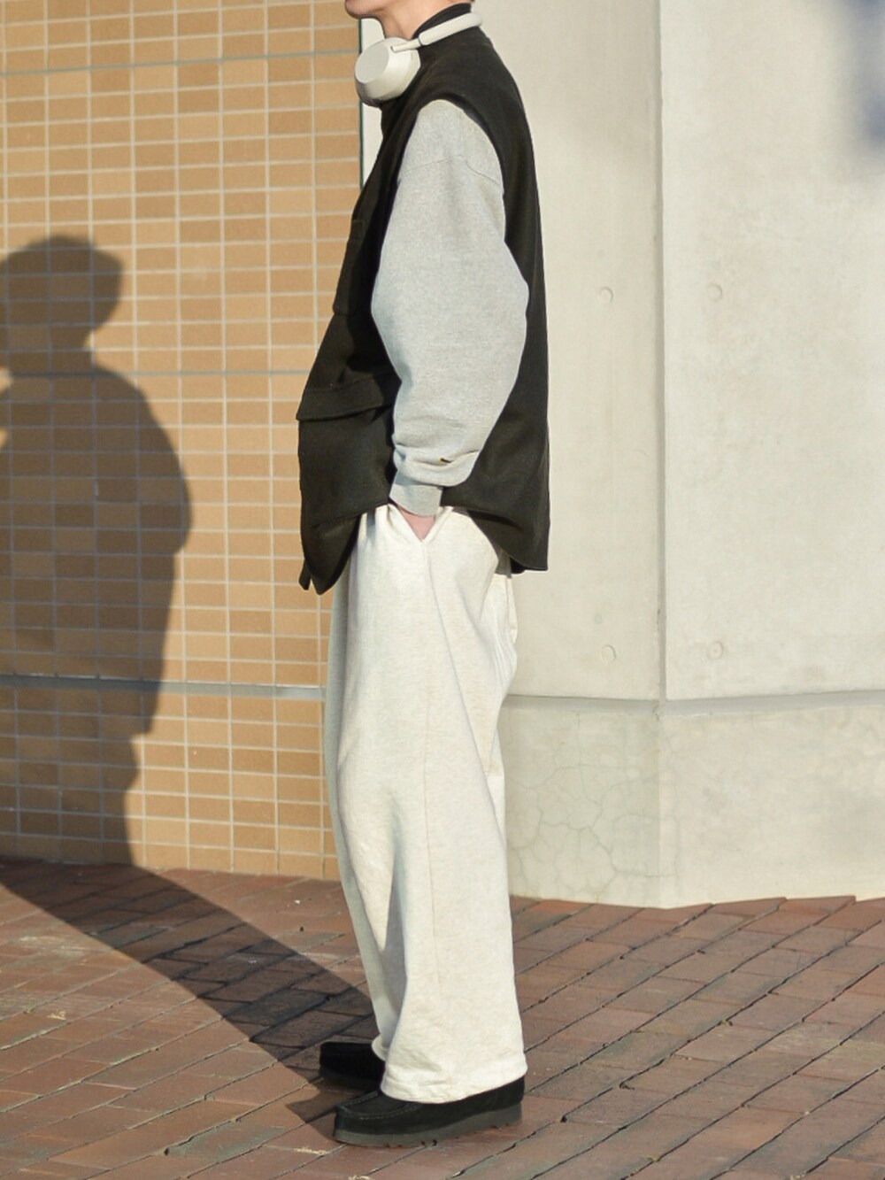 グレー系のスウェット、ホワイト系のスウェットパンツ、ブラック系のモカシン/デッキシューズを着用したメンズの冬コーディネートの3枚目の写真