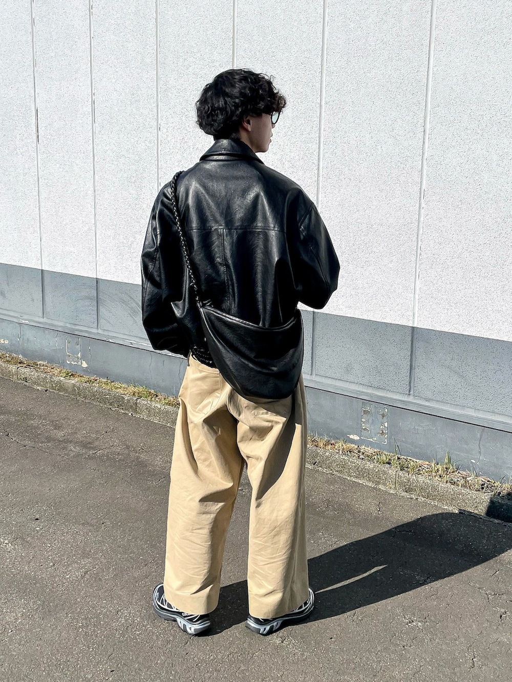 ブラック系のブルゾン、ブラック系のショルダーバッグ、ベージュ系のスウェットを着用したメンズの秋コーディネートの5枚目の写真