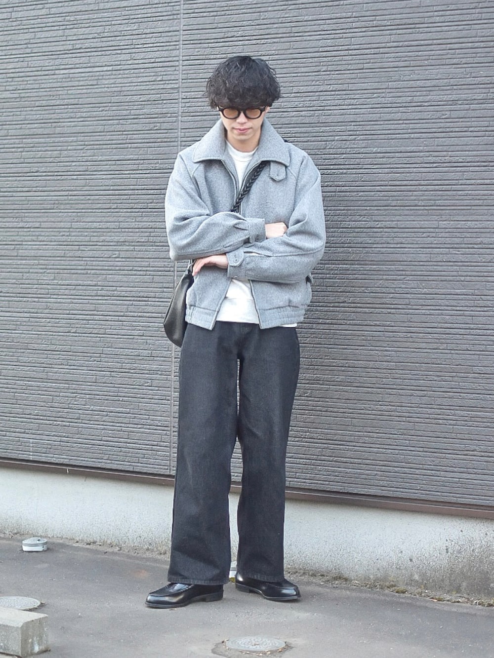 グレー系のブルゾン、グレー系のスウェット、ブラック系のデニムパンツを着用したメンズの冬コーディネートの4枚目の写真