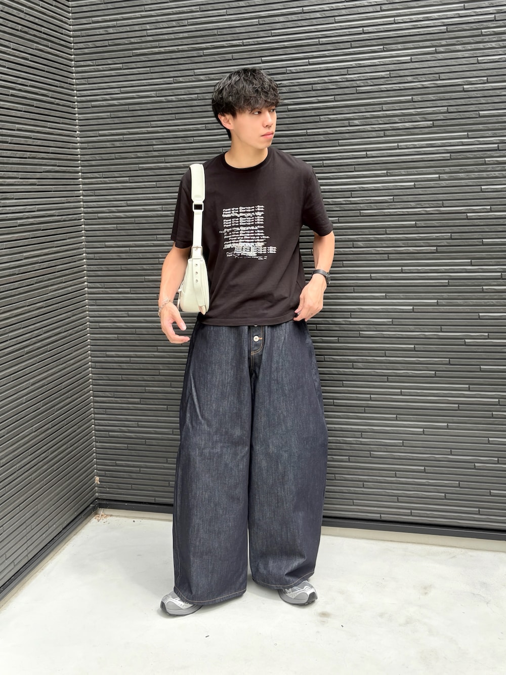 ブルー系のデニムパンツ、グレー系のスニーカー、ブラック系のTシャツ/カットソーを着用したメンズの夏コーディネートの4枚目の写真
