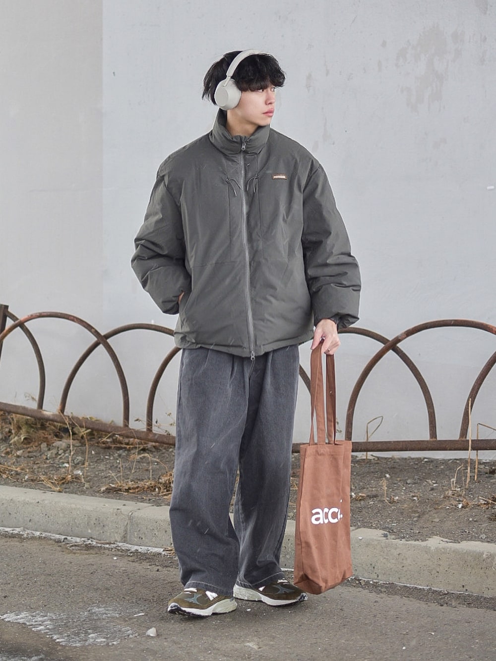 グレー系のジャケット/アウター、グレー系のデニムパンツ、ブラウン系のトートバッグを着用したメンズの冬コーディネートの2枚目の写真