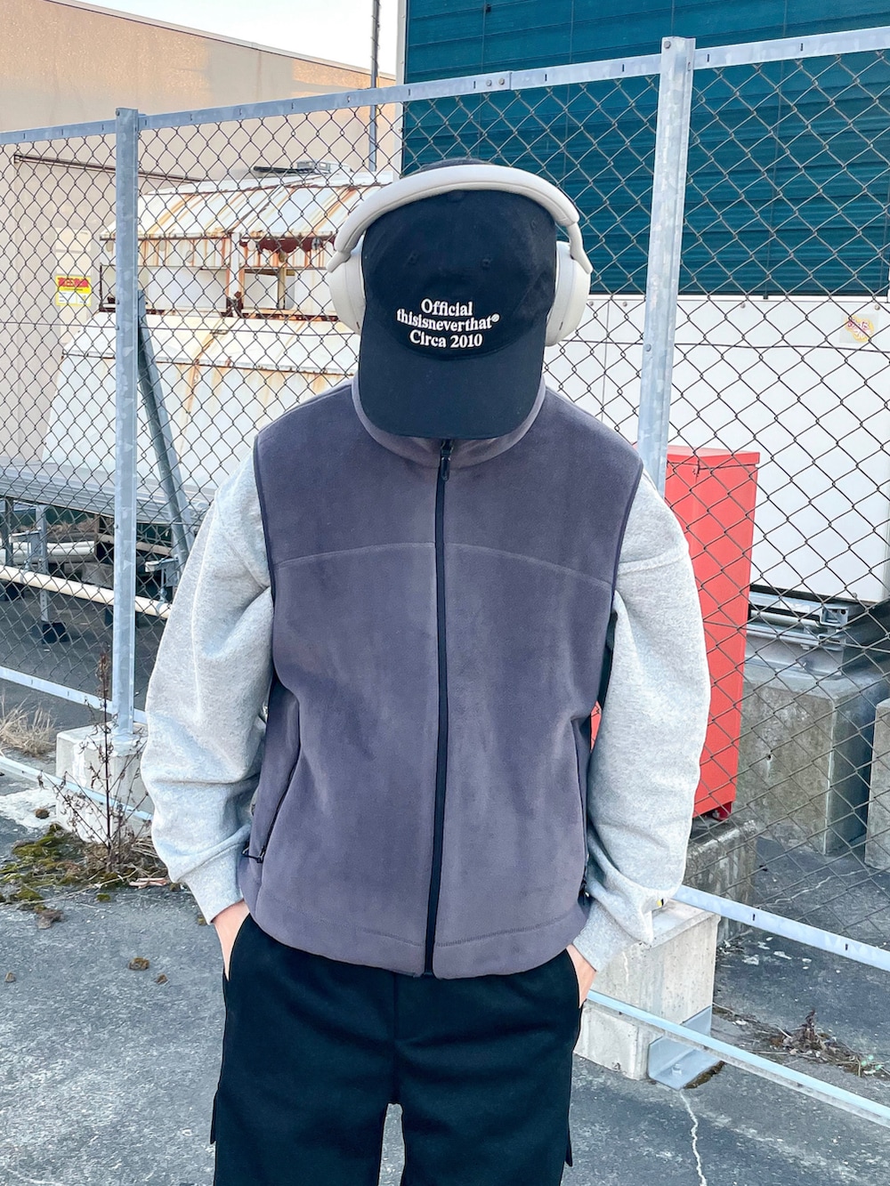 グレー系のベスト、ブラック系のカーゴパンツ、ブラック系のスニーカーを着用したメンズの冬コーディネートの4枚目の写真