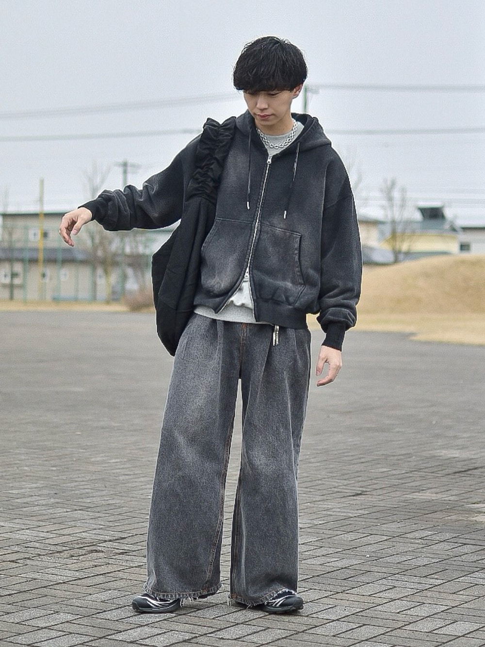 ブラック系のパーカー、グレー系のスウェット、ブラック系のデニムパンツを着用したメンズの春コーディネートの4枚目の写真