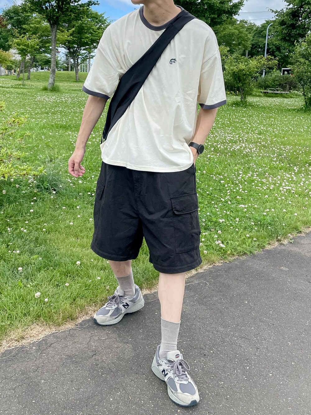 ホワイト系のトップス、ブラック系のパンツ、グレー系のスニーカーを着用したメンズの夏コーディネートの3枚目の写真