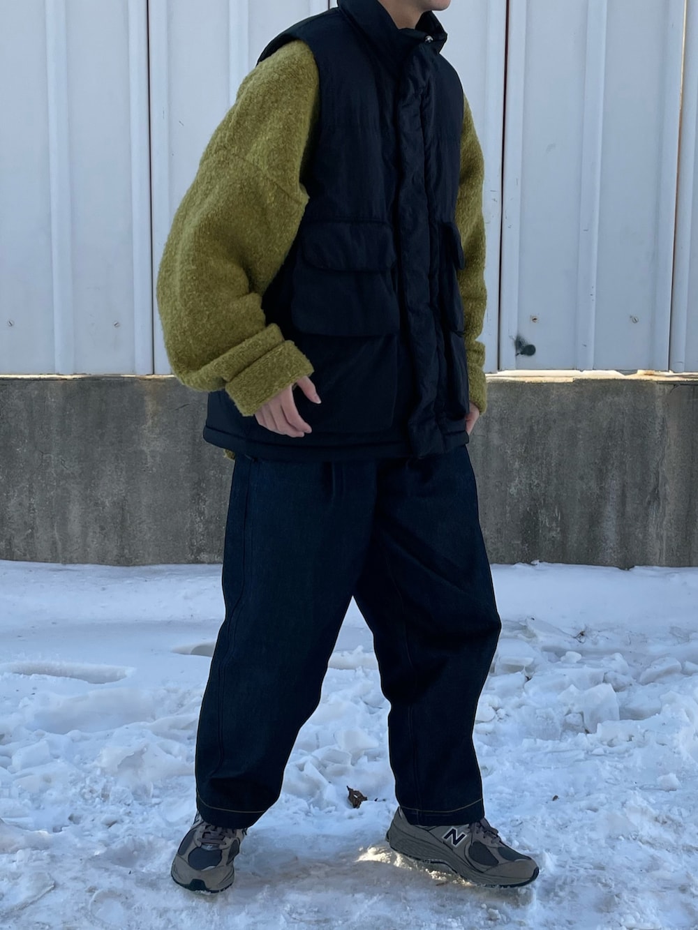 ブラック系のダウンベスト、グレー系のスニーカーを着用したメンズの冬コーディネートの3枚目の写真