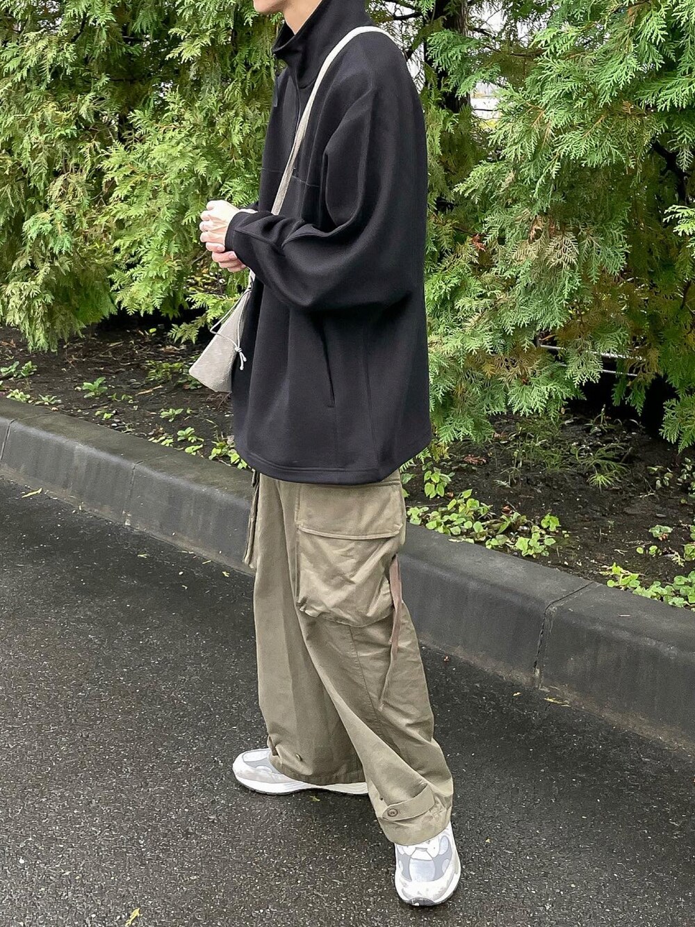 ブラック系のTシャツ/カットソー、グリーン系のカーゴパンツを着用したメンズの秋コーディネートの2枚目の写真