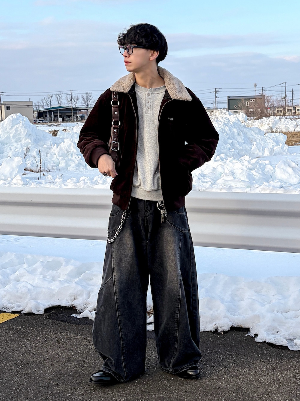 ブラウン系のブルゾン、グレー系のスウェット、ブラック系のデニムパンツを着用したメンズの冬コーディネートの2枚目の写真
