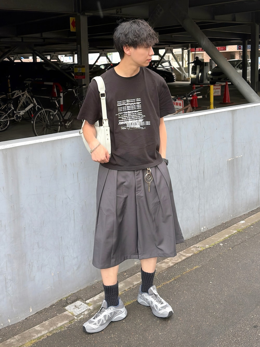ブラック系のTシャツ/カットソー、グレー系のスラックス、グレー系のスニーカーを着用したメンズの夏コーディネートの2枚目の写真