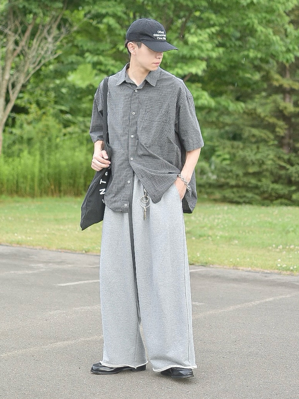 ブラック系のシャツ/ブラウス、グレー系のスウェットパンツ、ブラック系のトートバッグを着用したメンズの夏コーディネートの3枚目の写真