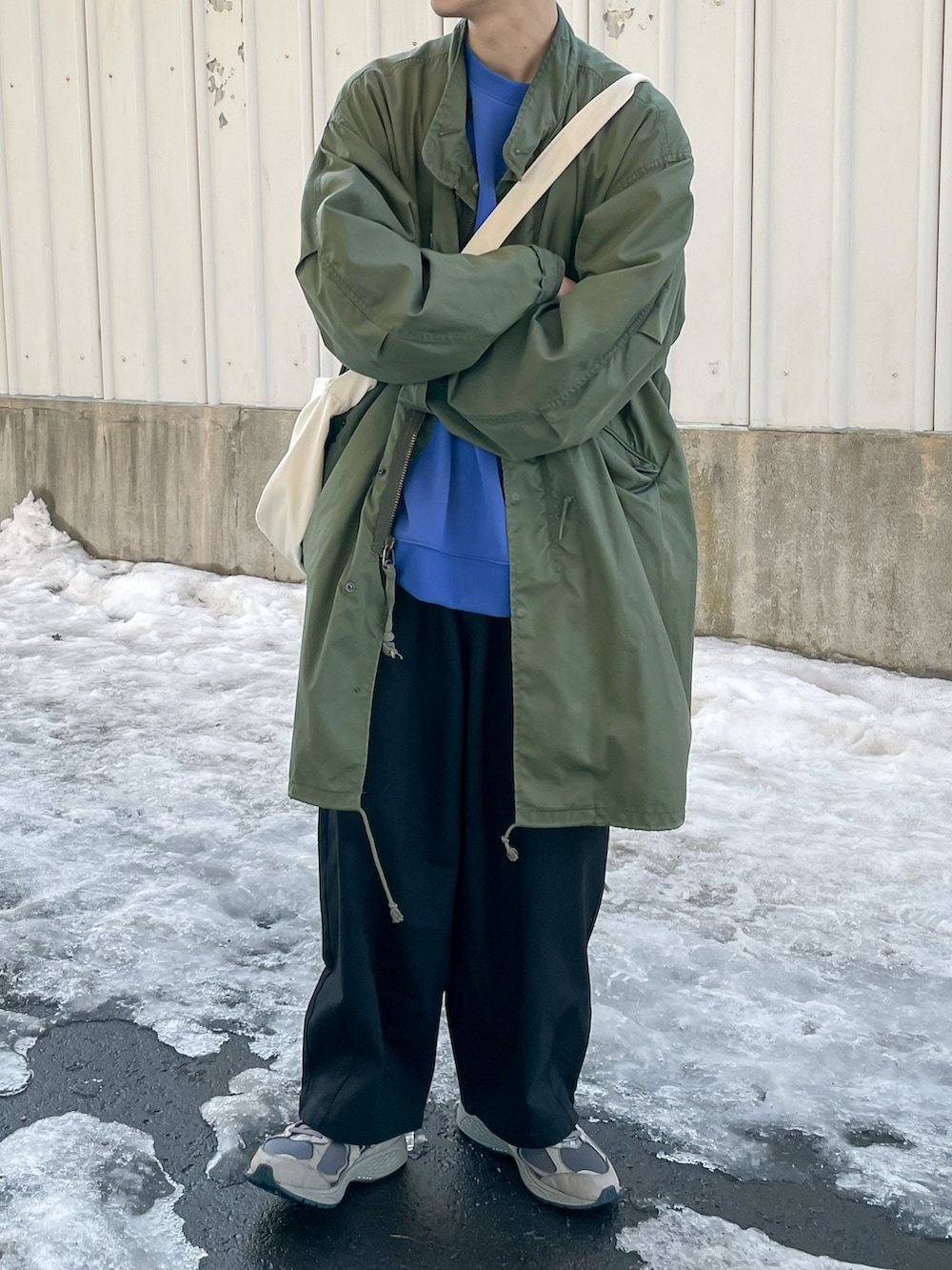 ブルー系のスウェット、ブラック系のチノパンツを着用したメンズの春コーディネートの3枚目の写真