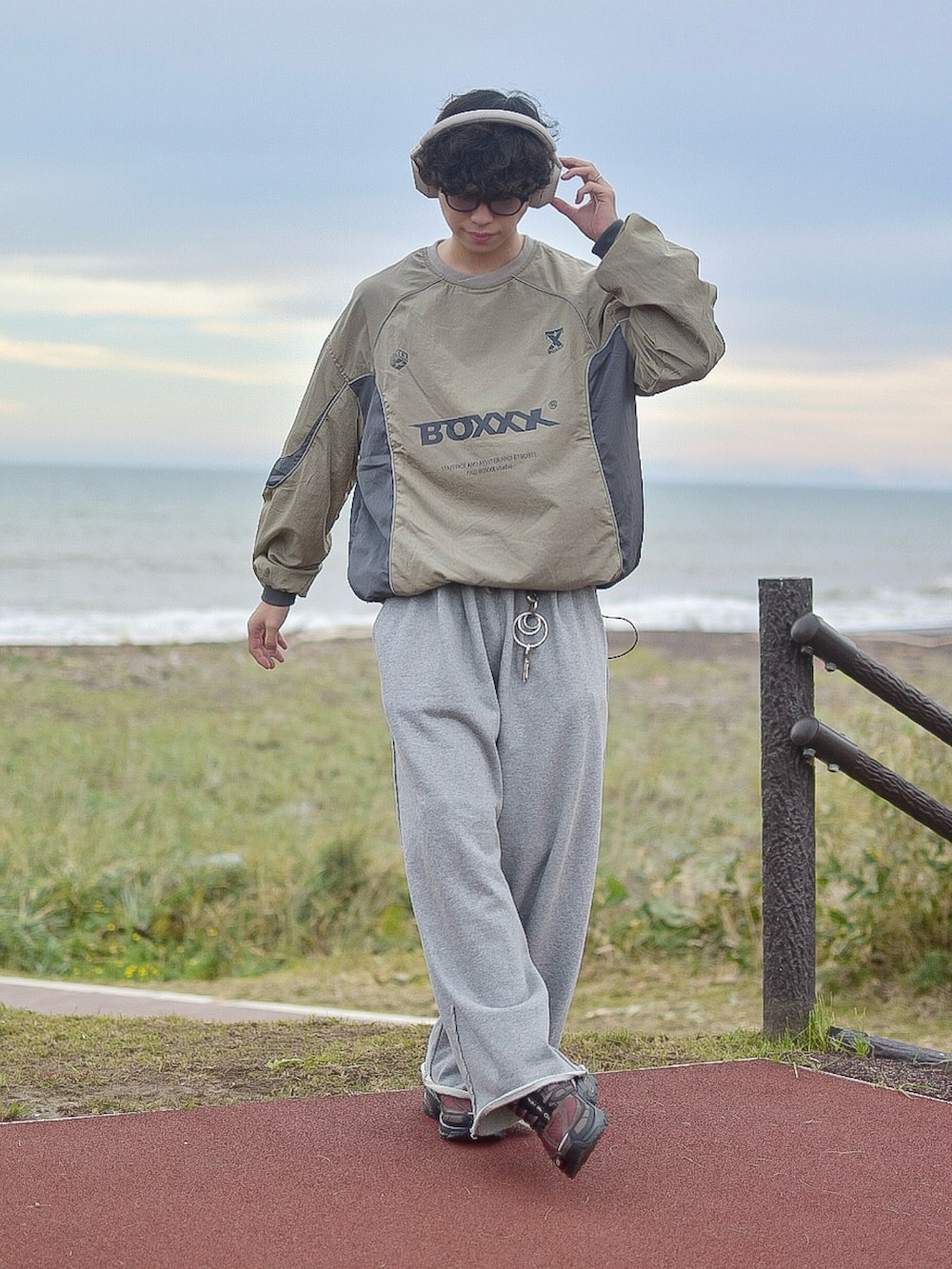 グリーン系のスウェット、グレー系のスウェットパンツ、ブラウン系のスニーカーを着用したメンズの秋コーディネートの3枚目の写真