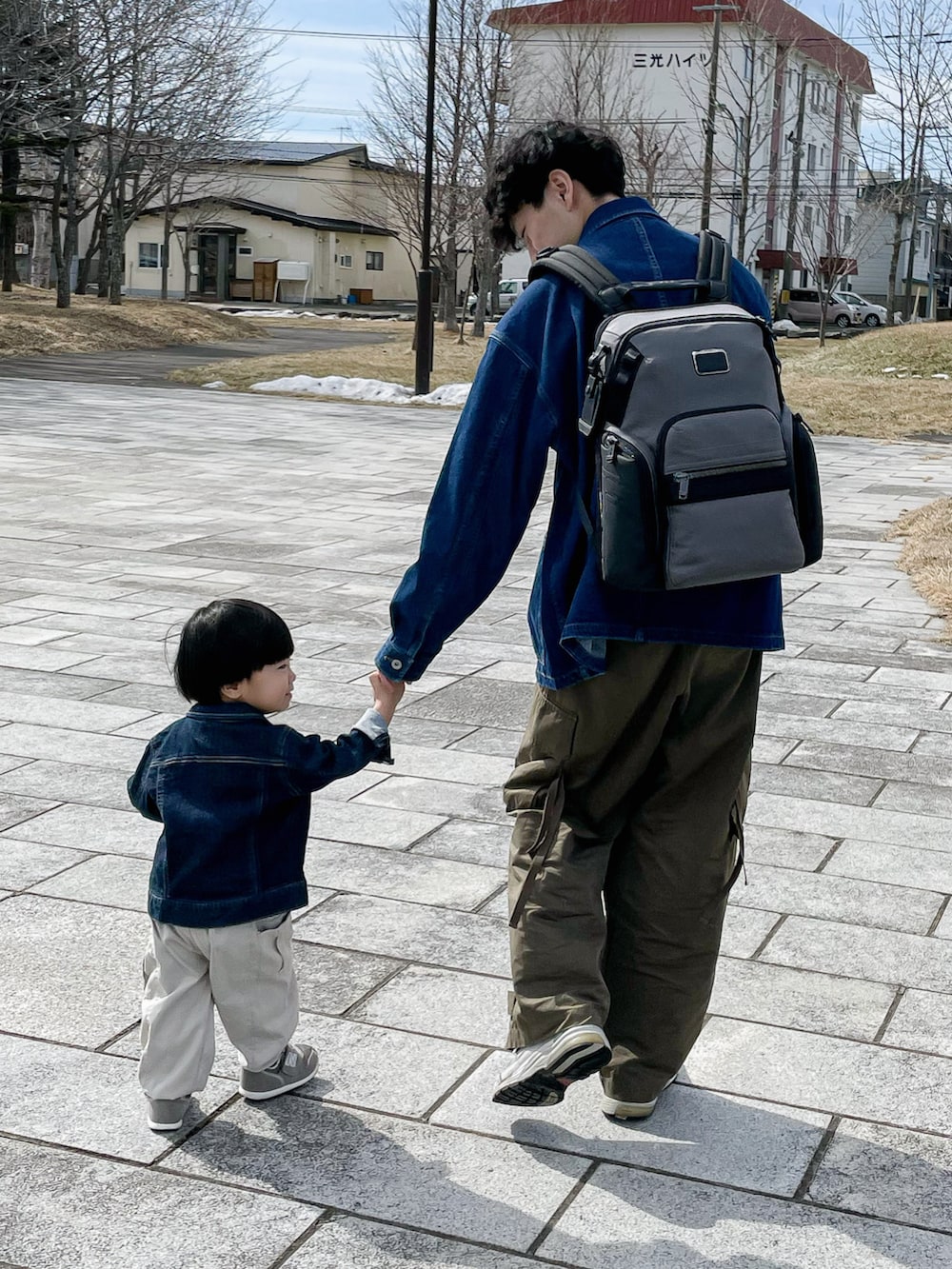 ブルー系のカバーオール、ベージュ系のスウェット、グリーン系のカーゴパンツを着用したメンズの春コーディネートの2枚目の写真
