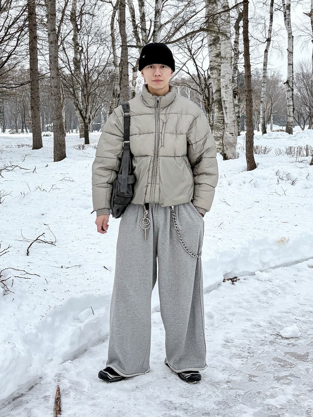 グレー系のスウェットパンツ、ブラック系のショルダーバッグ、グレー系のダウンジャケット/コートを着用したメンズの冬コーディネートの3枚目の写真