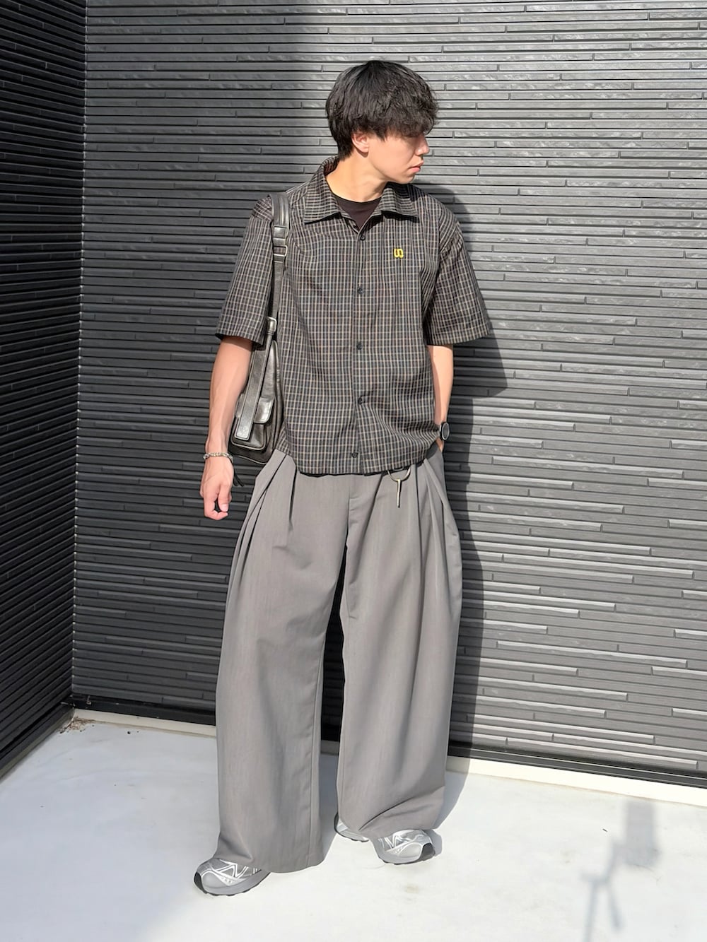 ブラック系のシャツ/ブラウス、グレー系のスラックス、グレー系のスニーカーを着用したメンズの夏コーディネートの2枚目の写真