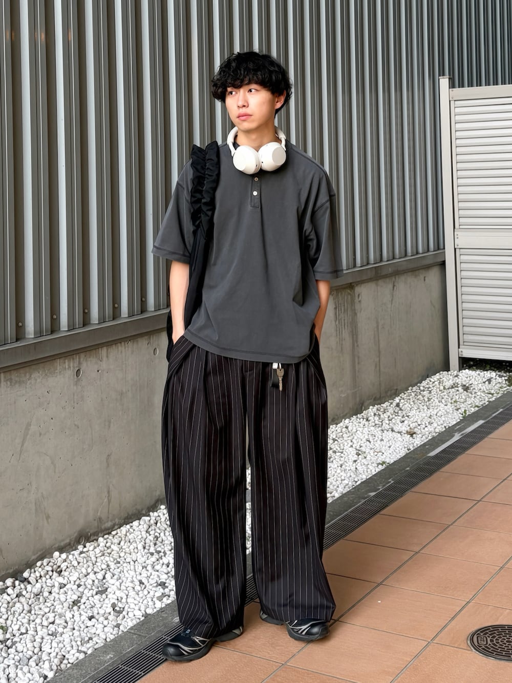 ブラック系のTシャツ/カットソー、ブラック系のスラックス、ブラック系のショルダーバッグを着用したメンズの夏コーディネートの3枚目の写真